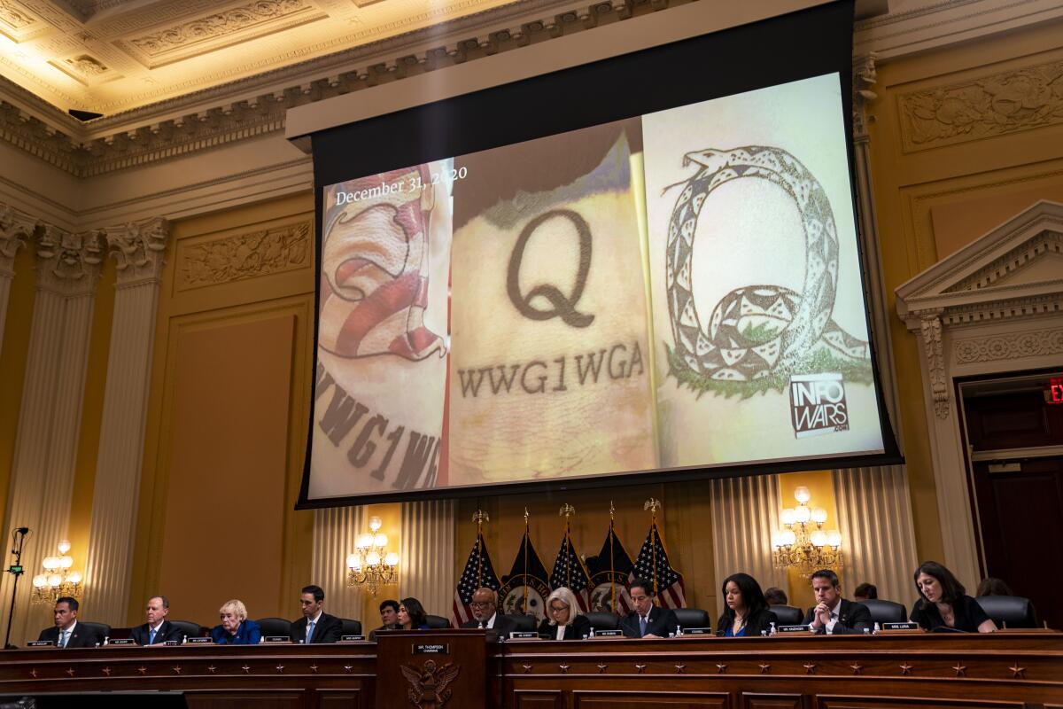 QAnon-themed tattoos are displayed on a screen.