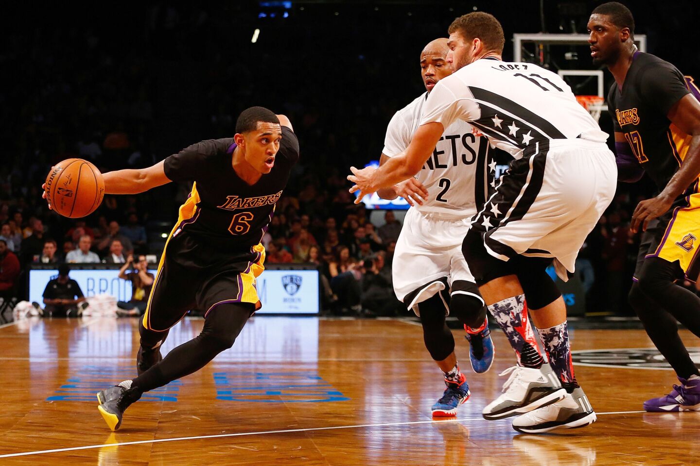 Los Angeles Lakers' Jordan Clarkson, left, drives to the basket against Brooklyn Nets' Brook Lopez (11) on Friday.