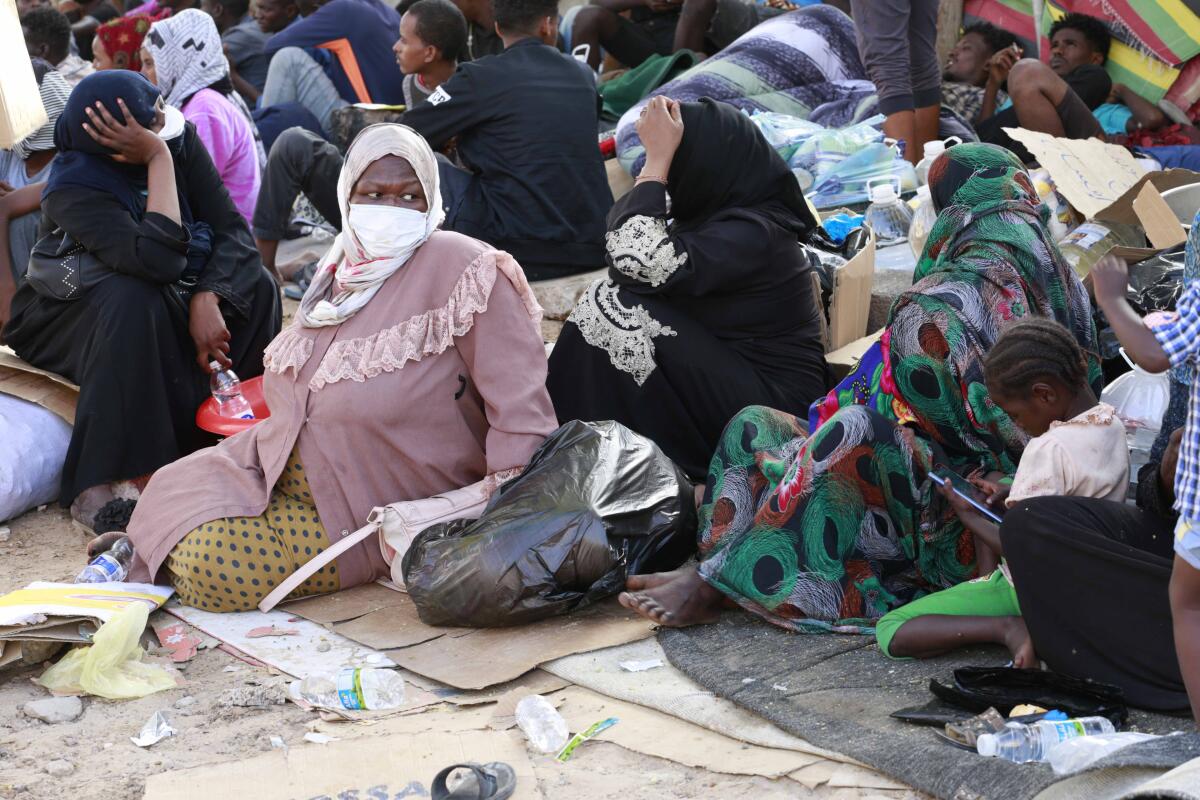 Women sit on the ground with children