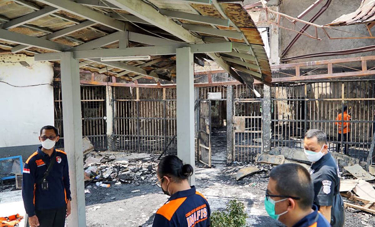 In this photo released by the Indonesian Ministry of Justice and Human Rights, police officers inspect damage cells after a fire at Tangerang Prison in Tangerang, Indonesia, Wednesday, Sept. 8, 2021. A massive fire raged through the overcrowded prison near Indonesia's capital early Wednesday, killing a number of inmates. (Indonesian Ministry of Justice and Human Rights via AP)