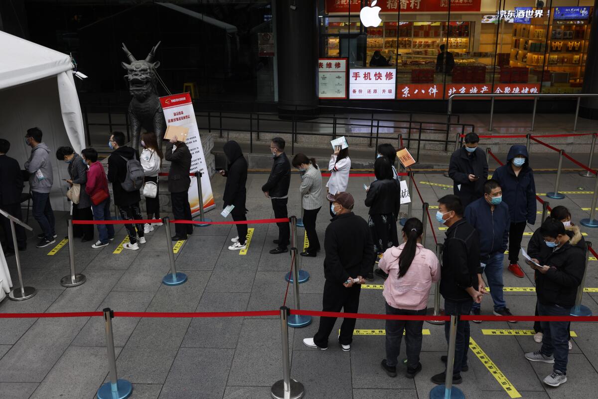 Residents line up for COVID-19 vaccinations at a shopping district in in Beijing. 