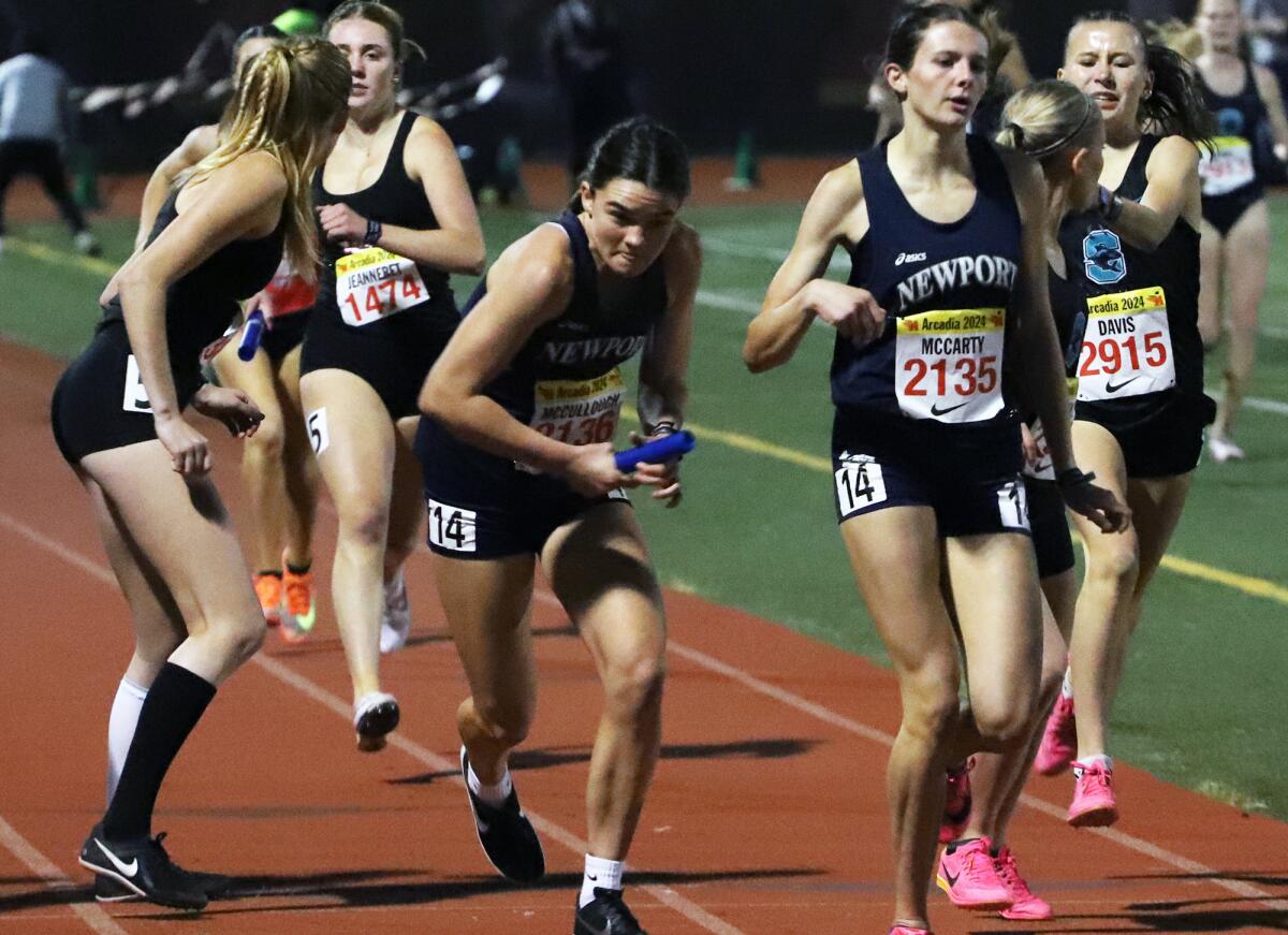 Newport Harbor's Marley McCullough takes the baton from Natalie McCarty in the girls' distance medley relay.