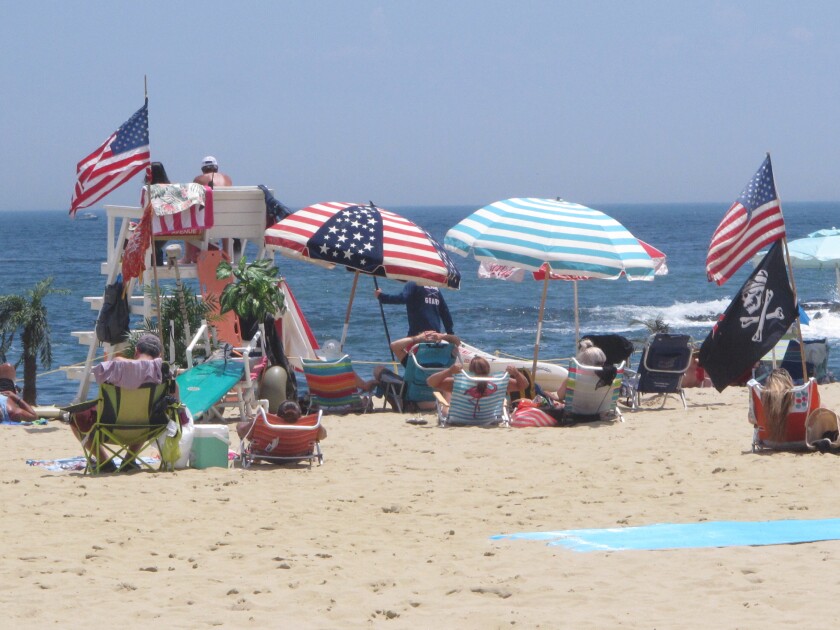 Flags line the beach in Belmar, N.J., on June 28, 2020. With large crowds expected at the Jersey Shore for the July Fourth weekend, some are worried that a failure to heed mask-wearing and social distancing protocols could accelerate the spread of the coronavirus. (AP Photo/Wayne Parry)