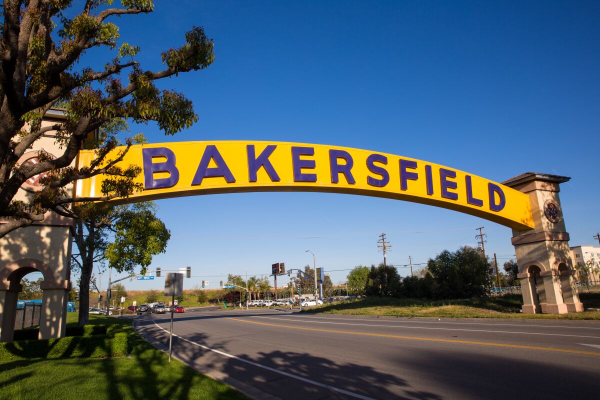 A sign saying "Bakersfield" straddles a street 