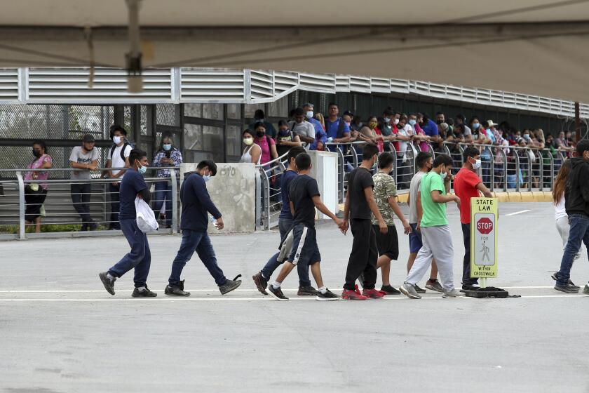 Varios inmigrantes son escoltados hacia un autobús en el Puente Internacional Hidalgo, el miércoles 2 de junio de 2021, en Hidalgo, Texas. (Delcia Lopez/The Monitor vía AP)