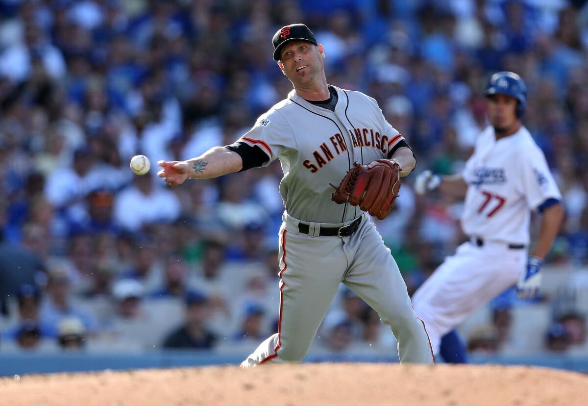 San Francisco pitcher Tim Hudson throws to first after fielding a ground ball to get the final out of the fifth inining Saturday against the Dodgers.