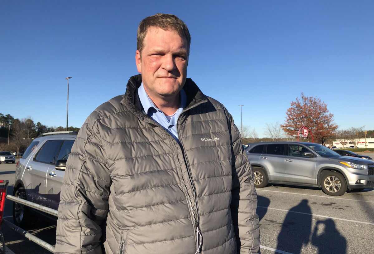 Steve Smith, 55, stands in a parking lot. 