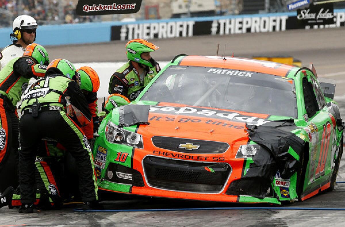 The crew of NASCAR driver Danica Patrick works on her damaged car during a pit stop Sunday at Phoenix International Raceway.