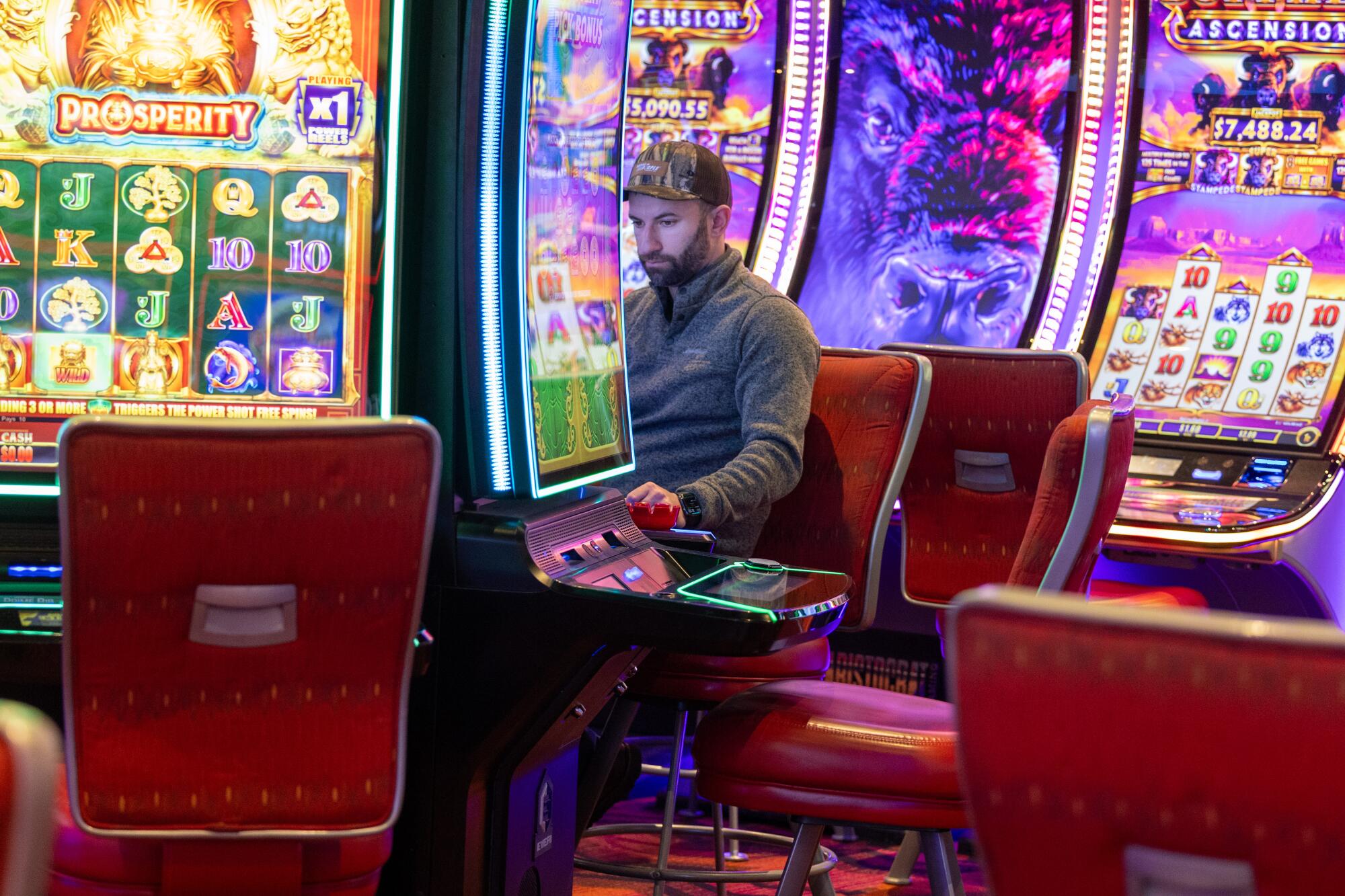 A patron plays colorful gaming machines 