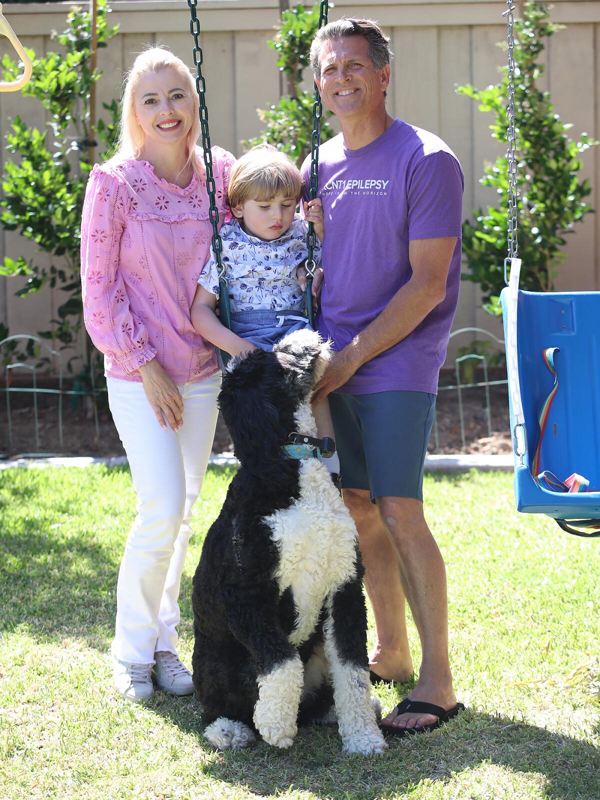 Andrew West, 7, swings in his backyard with parents Dr. Lisa Collea and Dr. Justin West, at their Newport Beach home.