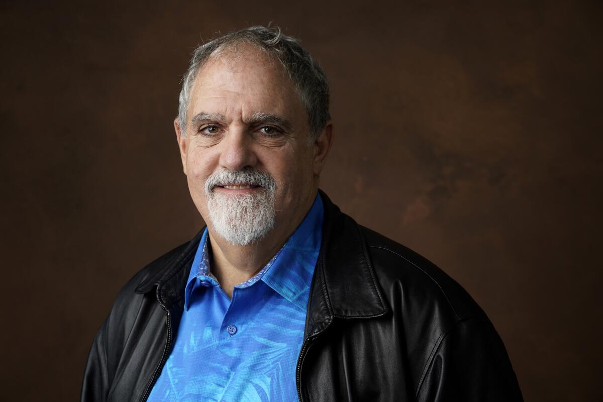 Jon Landau stands in a blue shirt and black jacket