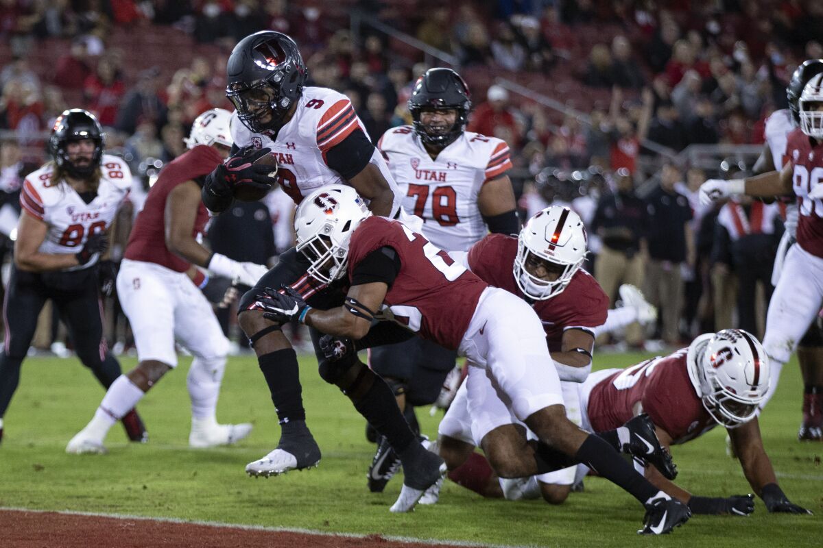 Utah running back Tavion Thomas (9) breaks the tackle attempt of Stanford cornerback Salim Turner-Muhammad (28) for a touchdown during the first quarter of an NCAA college football game Friday, Nov. 5, 2021, in Stanford, Calif. (AP Photo/D. Ross Cameron)