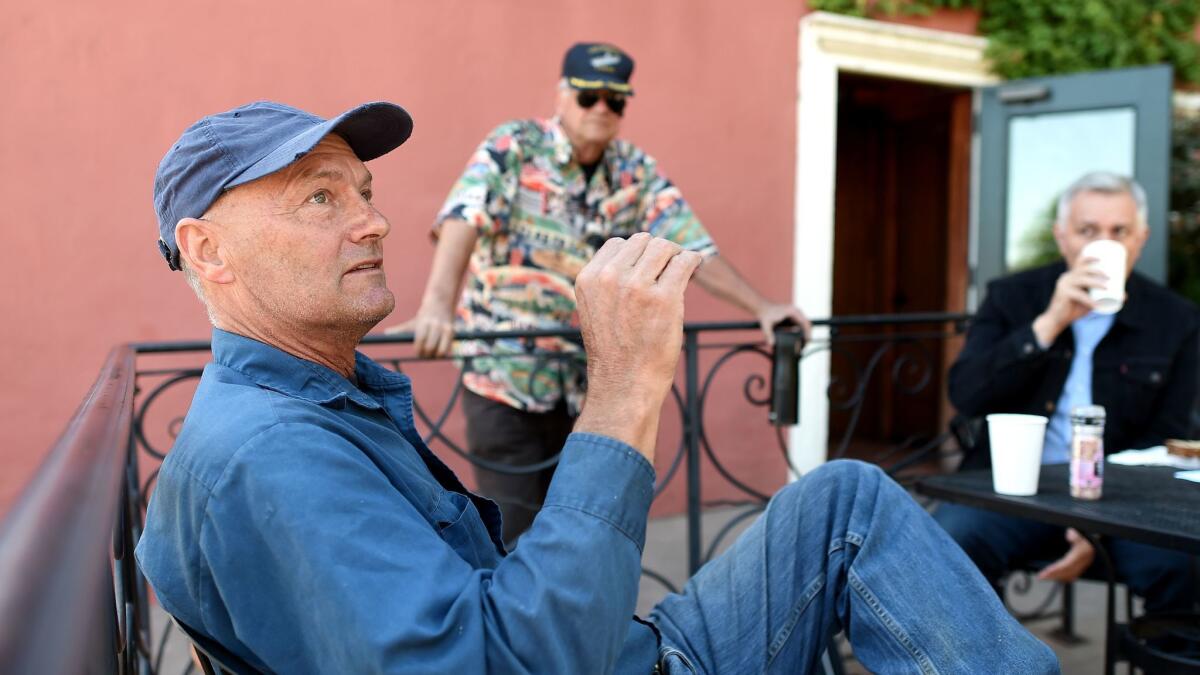 Bill Dettmer, left, speaks with a group of men who regularly meet and discuss local politics and civic issues at Madhouse Coffee in Brisbane, Calif. Dettmer thinks a developer should be allowed to build housing on an old rail yard in the city.