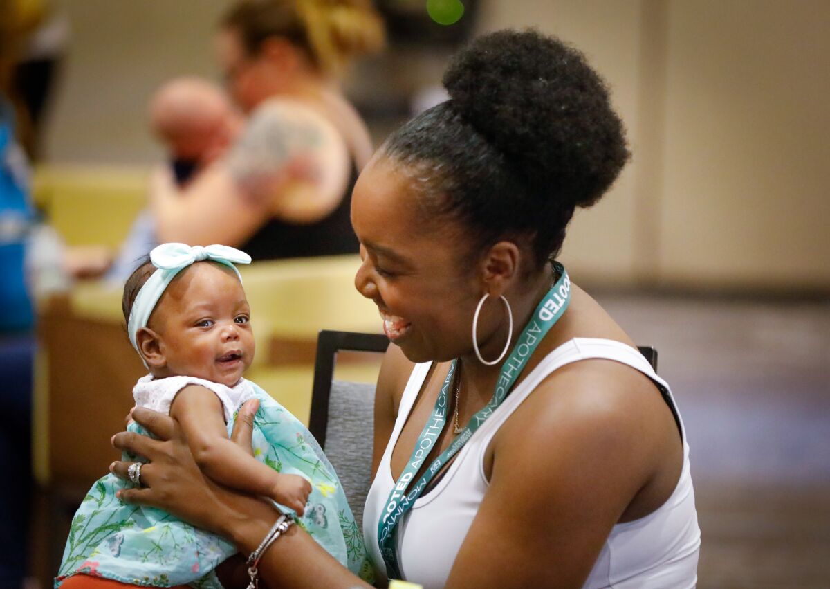 Dominique Pompey of Chula Vista holds her 5-month-old daughter, Mila Pompey, while attending MommyCon San Diego 2019 on Saturday at the Mission Valley Marriott Hotel.