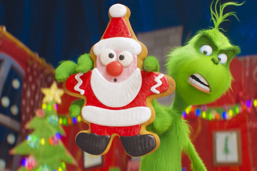 The Grinch (Benedict Cumberbatch) warns his dog Max and reindeer Fred about the seductive power of the Santa cookie as he trains them to help him steal Christmas in Dr. Seuss? "The Grinch" from Illumination. Credit: Illumination and Universal Pictures