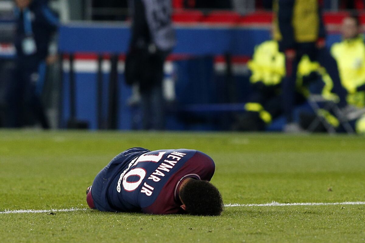 El jugador de PSG, Neymar, aparece tirado en el césped tras sufrir una lesión en un partido contra Marsella por la liga francesa el domingo, 25 de febrero de 2018, en París.
