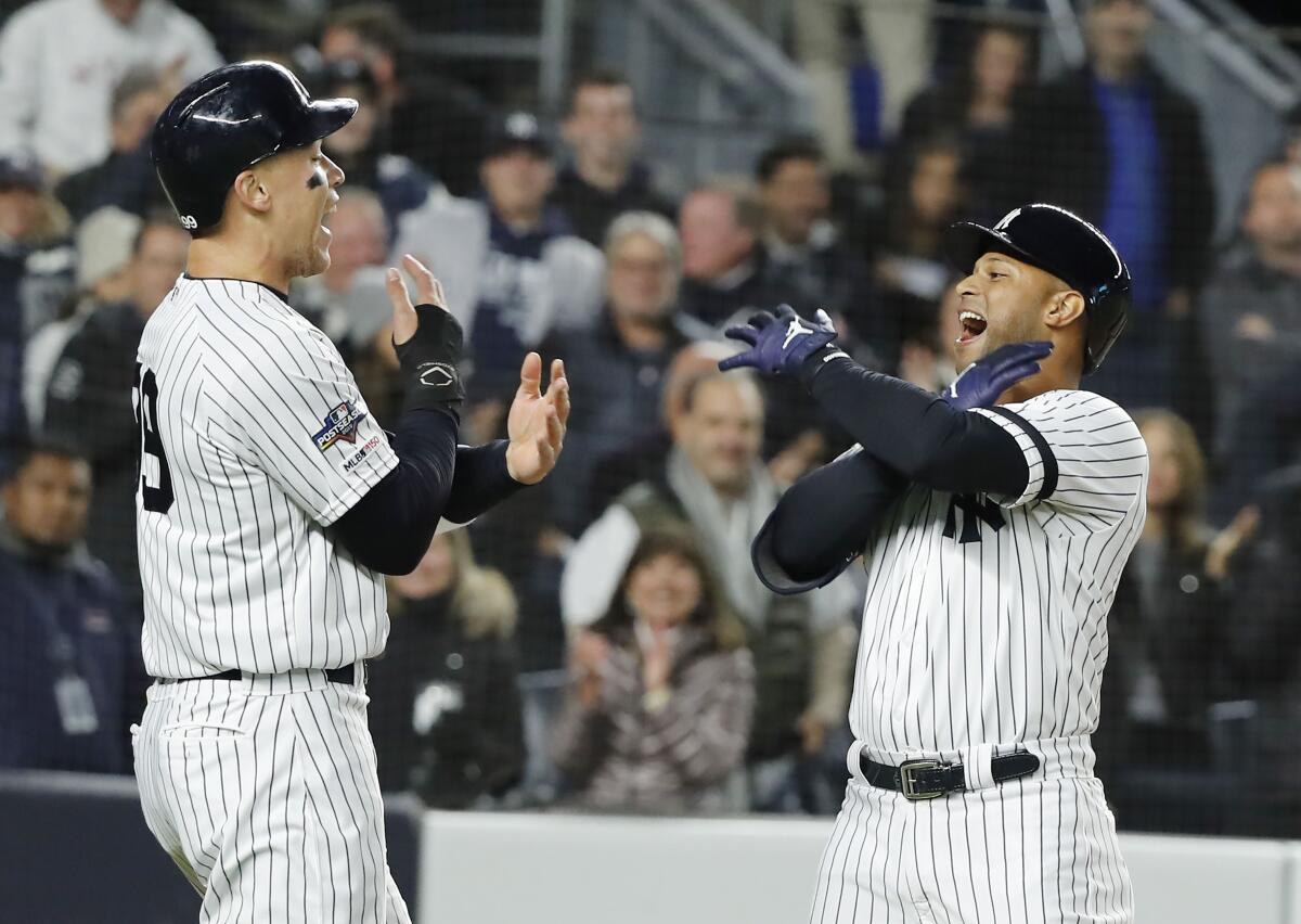 New York Yankees' batter Aaron Hicks, right, celebrates with teammate Aaron Judge after hitting a three-run home run in the bottom of the first inning against the Houston Astros in Game 5 of the ALCS on Friday in New York.