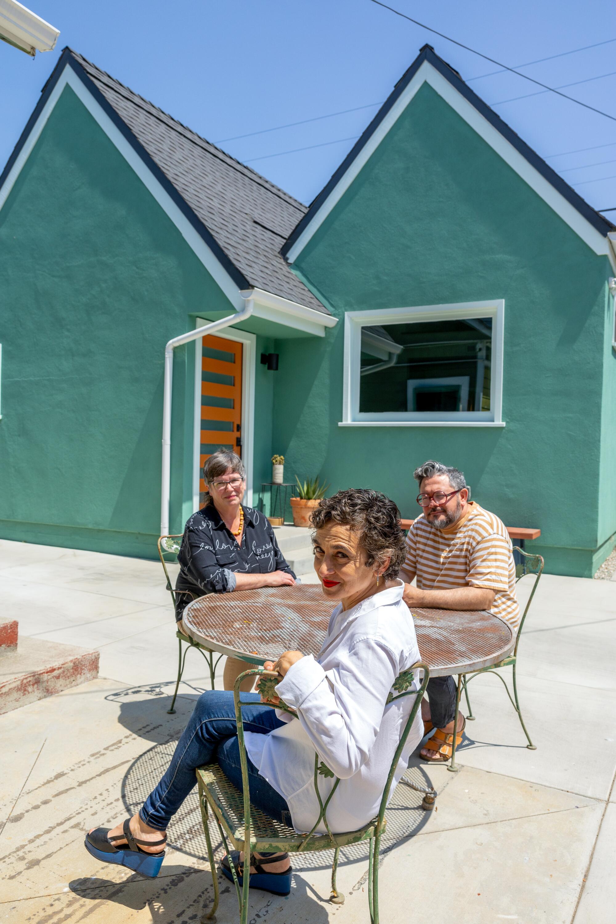 Architect Rachel Allen and homeowners Julie Zemel and Vladimir Gallegos in front of a green ADU