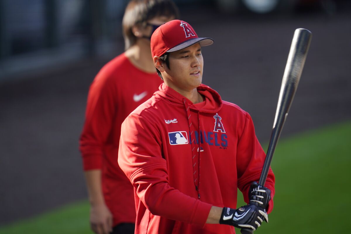 Shohei Ohtani, in batting gloves, holds a bat during a pregame warmup.
