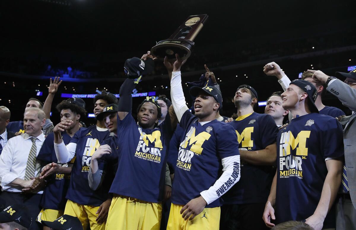 Michigan players celebrate after beating Florida State in an NCAA men's college basketball tournament regional final Saturday, March 24, 2018, in Los Angeles.