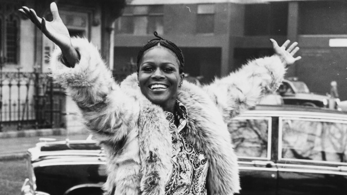 A young Cicely Tyson smiles in a fur coat