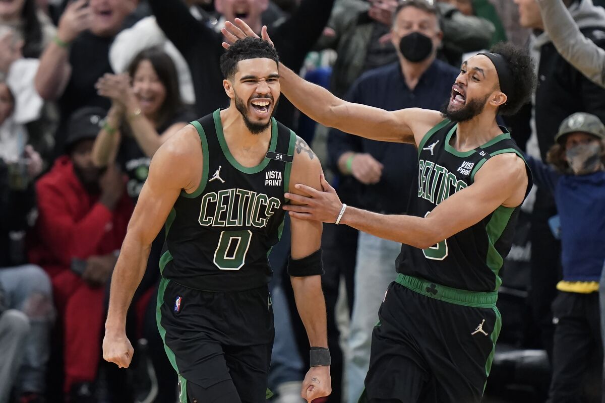 Boston Celtics forward Jayson Tatum (0) celebrates with guard Derrick White (9) after making a layup at the buzzer to score and win Game 1 of an NBA basketball first-round Eastern Conference playoff series against the Brooklyn Nets, Sunday, April 17, 2022, in Boston. The Celtics won 115-114. (AP Photo/Steven Senne)
