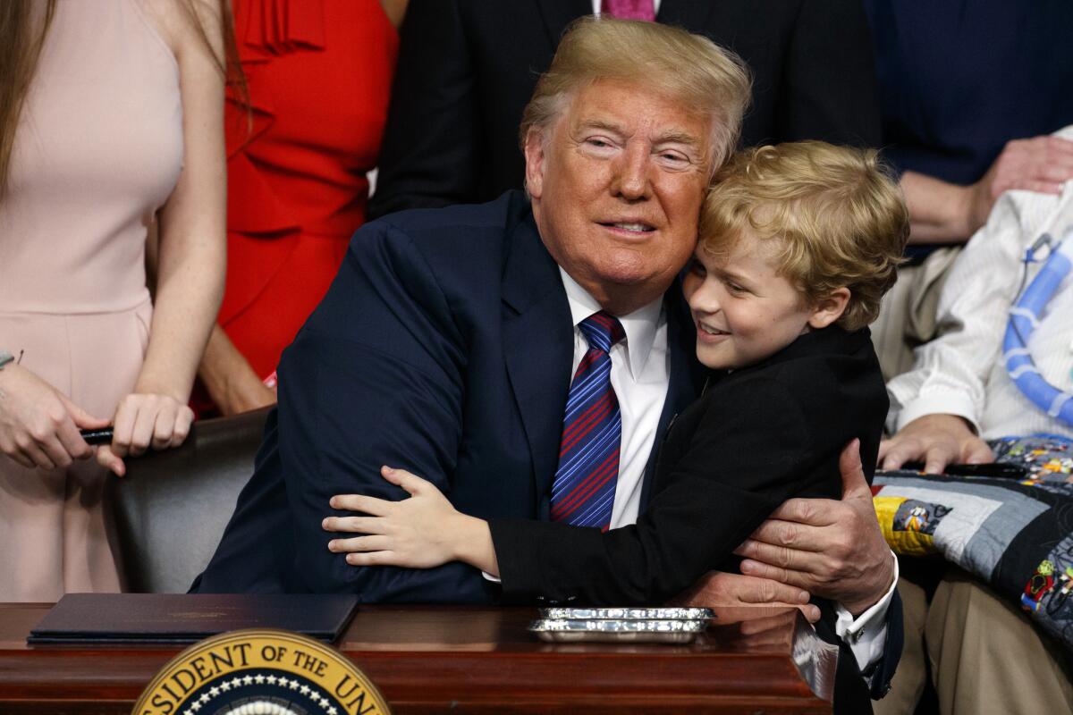 President Trump hugs Jordan McLinn, who has Duchenne muscular dystrophy, after signing the "Right to Try" act Wednesday.