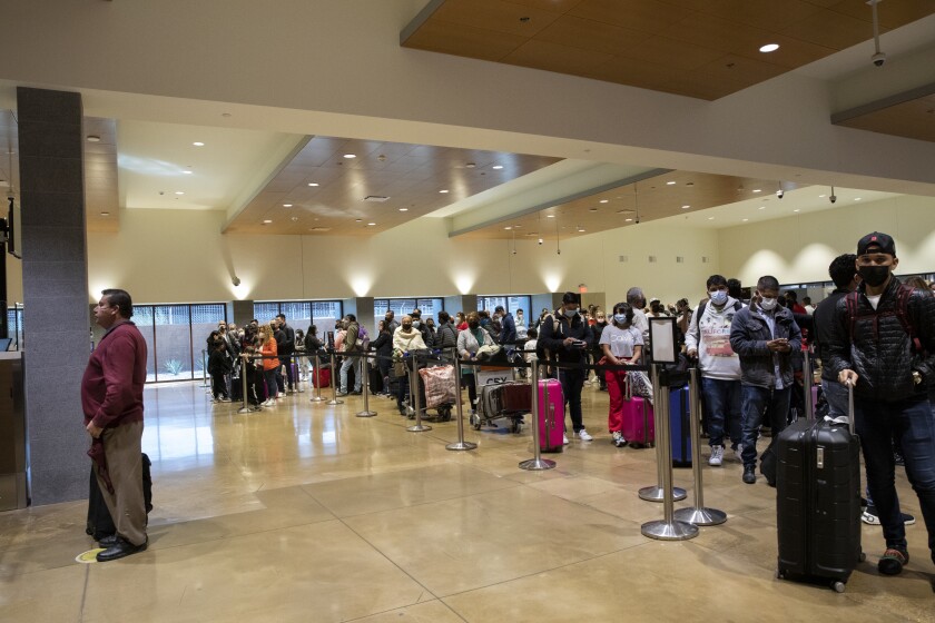 People wait in line at the U.S. Customs and Border Protection area of Cross Border Xpress