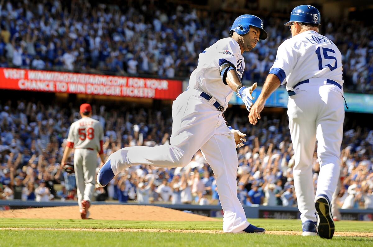 Dodgers left fielder Carl Crawford is congratulated by first base coach Davey Lopes after hitting a home run in the fifth inning of Game 5.