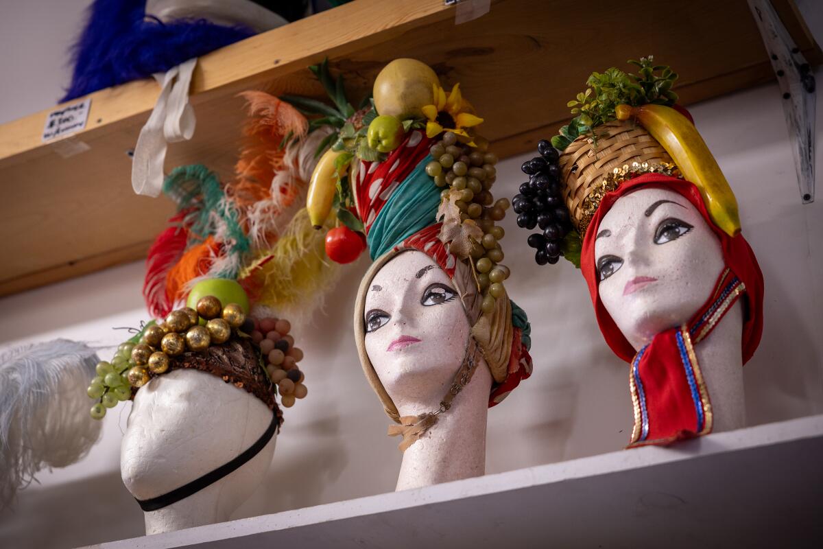 Three mannequin heads wearing Carmen Miranda-style fruit headdresses