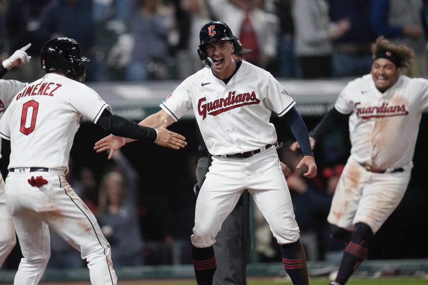Cleveland Guardians' Will Brennan, center, celebrates with Andrés Giménez (0) after scoring the winning run in the ninth inning of the team's baseball game against the Baltimore Orioles, Friday, Sept. 22, 2023, in Cleveland. (AP Photo/Sue Ogrocki)