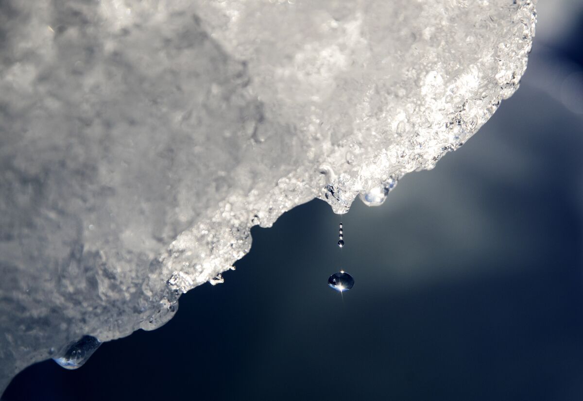 FILE - A drop of water falls off an iceberg melting in the Nuup Kangerlua Fjord near Nuuk in southwestern Greenland, Tuesday, Aug. 1, 2017. According to a report by the U.S. National Oceanic and Atmospheric Administration released on Tuesday, Dec. 14, 2021, the Arctic continues to deteriorate from global warming, not setting as many records this year as in the past, but still changing so rapidly that federal scientists call it alarming. (AP Photo/David Goldman)