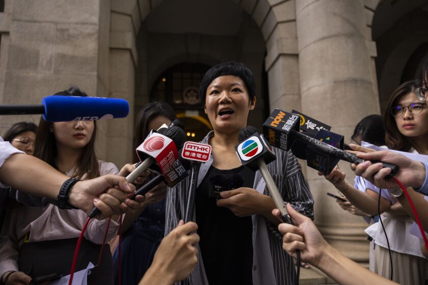 Journalist Bao Choy, center, speaks to members of the press after being cleared by Top Hong Kong court in Hong Kong, Monday, June 5, 2023. The award-winning Hong Kong journalist won an appeal quashing her conviction related to work on her investigative documentary Monday in a rare court ruling upholding media freedom in the territory. (AP Photo/Louise Delmotte)