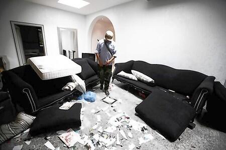 An anti-Gaddafi fighter walks inside the living room of a house belonging to Muammar Gaddafi's son Hannibal in Tripoli.