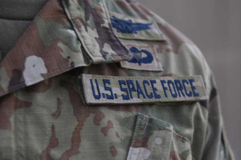In this photo released by the U.S. Air Force, Capt. Ryan Vickers stands for a photo to display his new service tapes after taking his oath of office to transfer from the U.S. Air Force to the U.S. Space Force at Al-Udeid Air Base, Qatar, Tuesday, Sept. 1, 2020. Space Force, the first new U.S. military service since the creation of the Air Force in 1947, now has some 20 members stationed at Qatar's Al-Udeid Air Base in its first foreign deployment. (Staff Sgt. Kayla White/U.S. Air Force via AP)