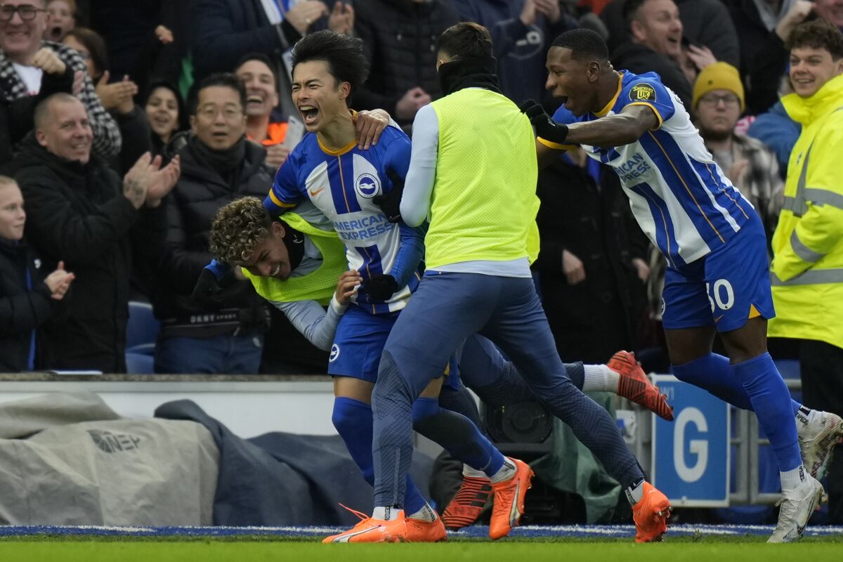 Brighton's Kaoru Mitoma, left, celebrates after scoring his side's second goal during the FA Cup 4th round soccer match between Brighton and Hove Albion and Liverpool at the Falmer Stadium in Brighton, England, Sunday, Jan. 29, 2023. (AP Photo/Alastair Grant)