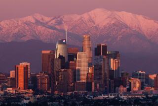 Los Angeles, CA - February 10: Skyscrapers in Downtown Los Angeles reflect the setting sun against a backdrop of the snow-capped San Gabriel Mountains on Saturday, Feb. 10, 2024 in Los Angeles, CA. (Brian van der Brug / Los Angeles Times)
