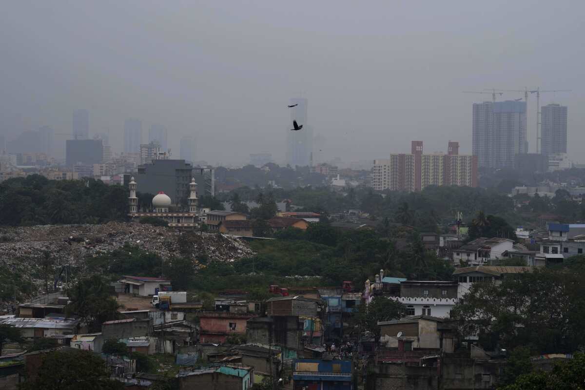 Smog and fog envelop the skyline in Colombo, Sri Lanka, Friday, Dec. 9, 2022. Schools across Sri Lanka were closed on Friday as health and environment officials said air quality was unhealthy in most parts of the island nation partly due to extreme weather conditions. (AP Photo/Eranga Jayawardena)