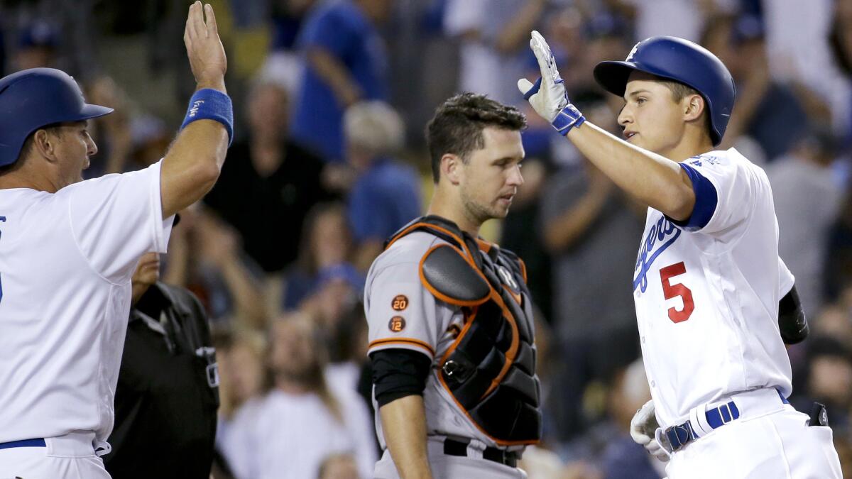 Dodgers shortstop Corey Seager is congratulated by teammate A.J. Ellis after hitting a two-run home run against the Giants in the eight inning Saturday.