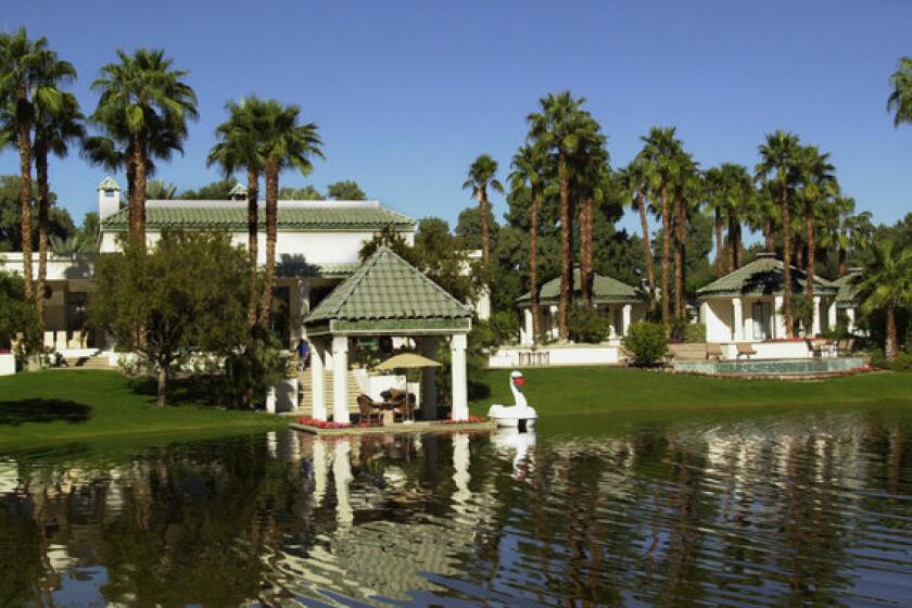 The main house, left, and two guest houses at Merv Griffin's former desert retreat can be seen across a lagoon.