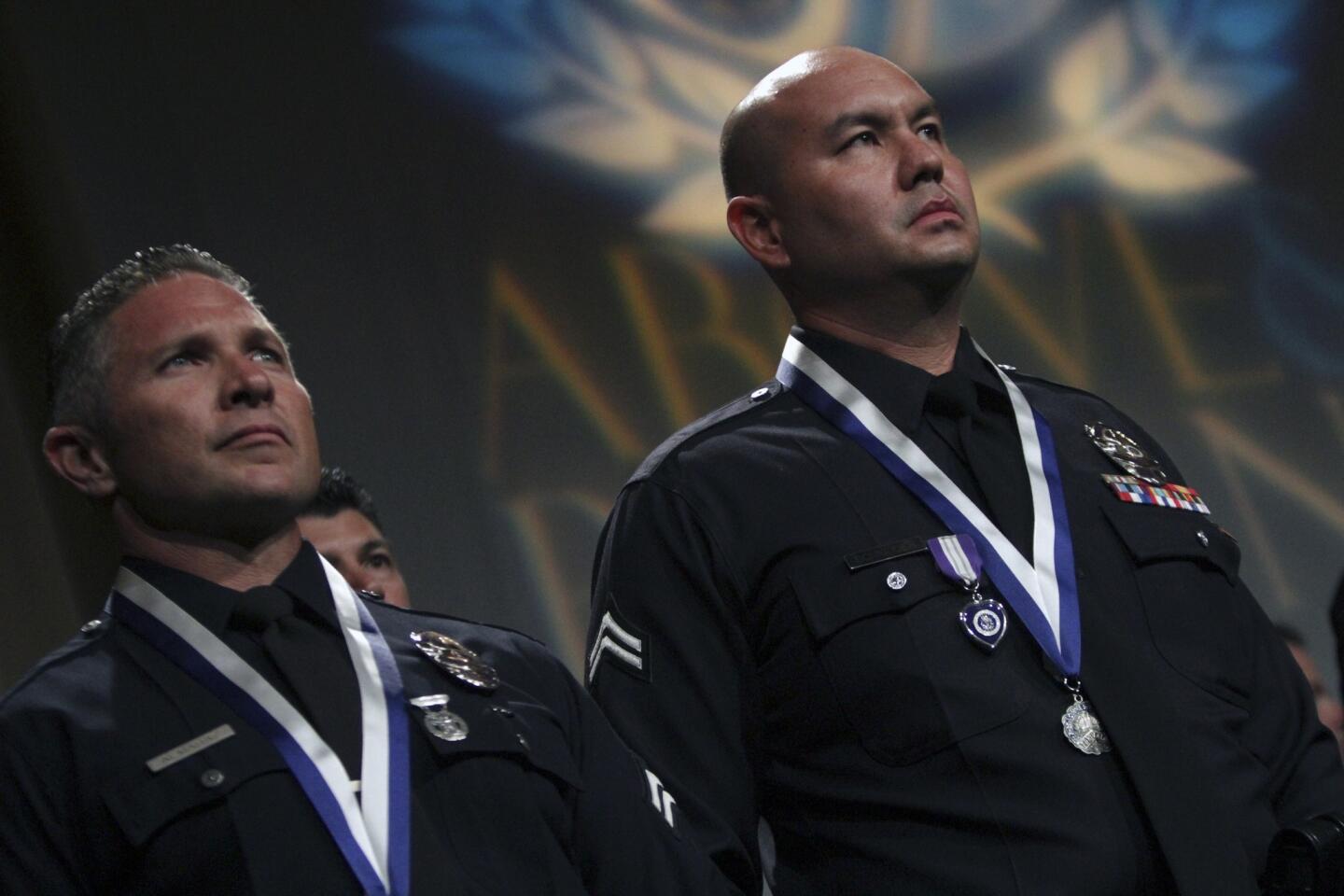 LAPD Officer Sean Schneider, right, received a Purple Heart and a Medal of Valor at the LAPD Above and Beyond award presentation at the Dolby Theatre at Hollywood & Highland.