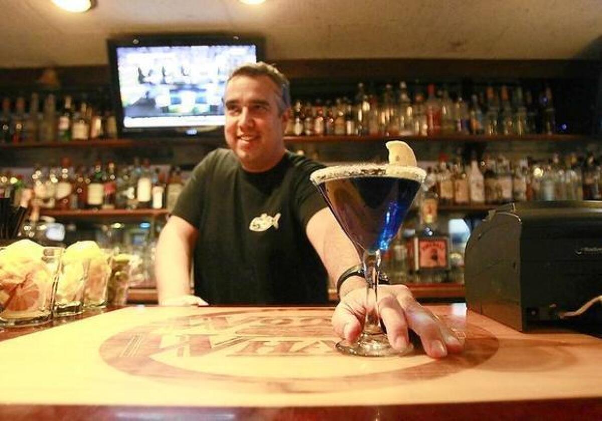 Bartender Michael Guerin serves up a fancy blue martini early in the evening at Woody's Wharf on the Balboa Peninsula.