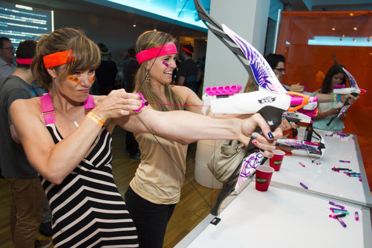 Guests try out items from the new Nerf Rebelle collection from Hasbro in New York. Revenue slumped for Hasbro in the second quarter.
