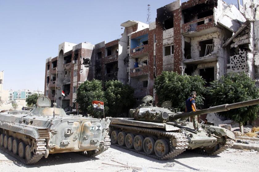 Government tanks sit idle in the recently recaptured town of Adra Al-Omaliya near Damascus, Syria. The U.N. has been urged to ban the trade of Syrian antiquities amid reports of looting in the region.