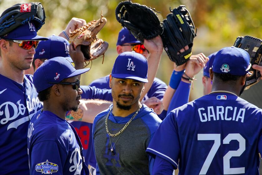 Dodgers right fielder Mookie Betts (50) is surrounded by teammates during spring training.