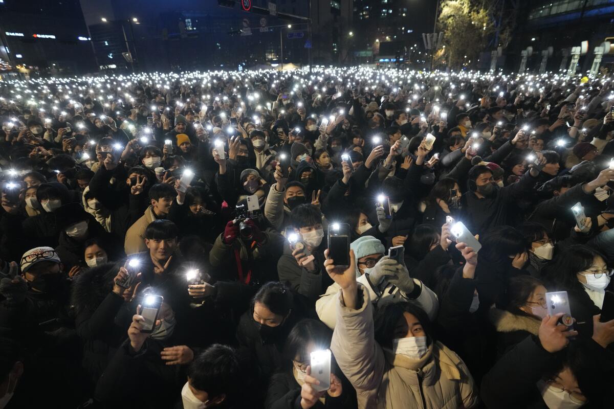 A crowd of people with lighted phones.