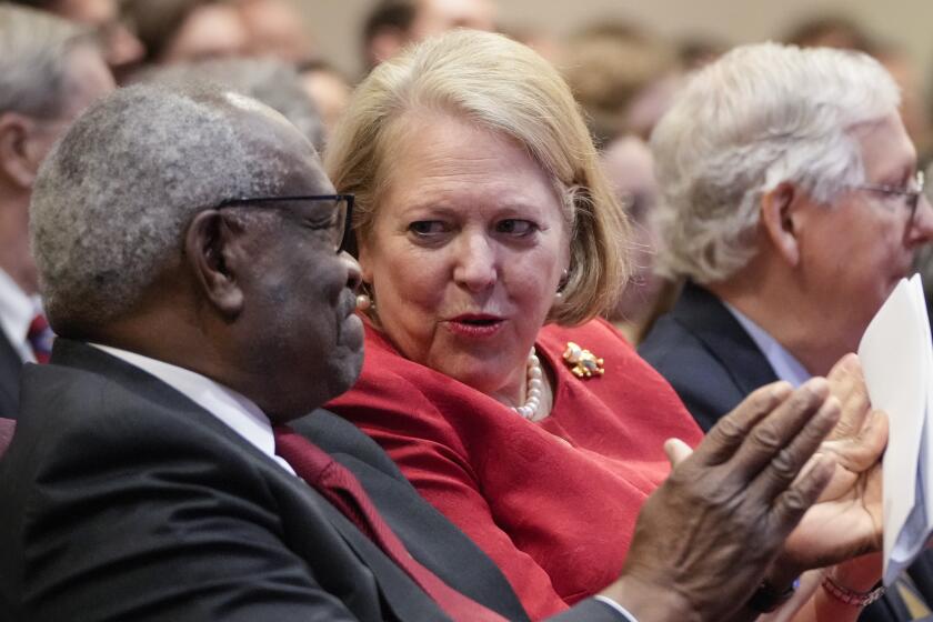 Associate Supreme Court Justice Clarence Thomas sits with his wife and conservative activist Virginia Thomas