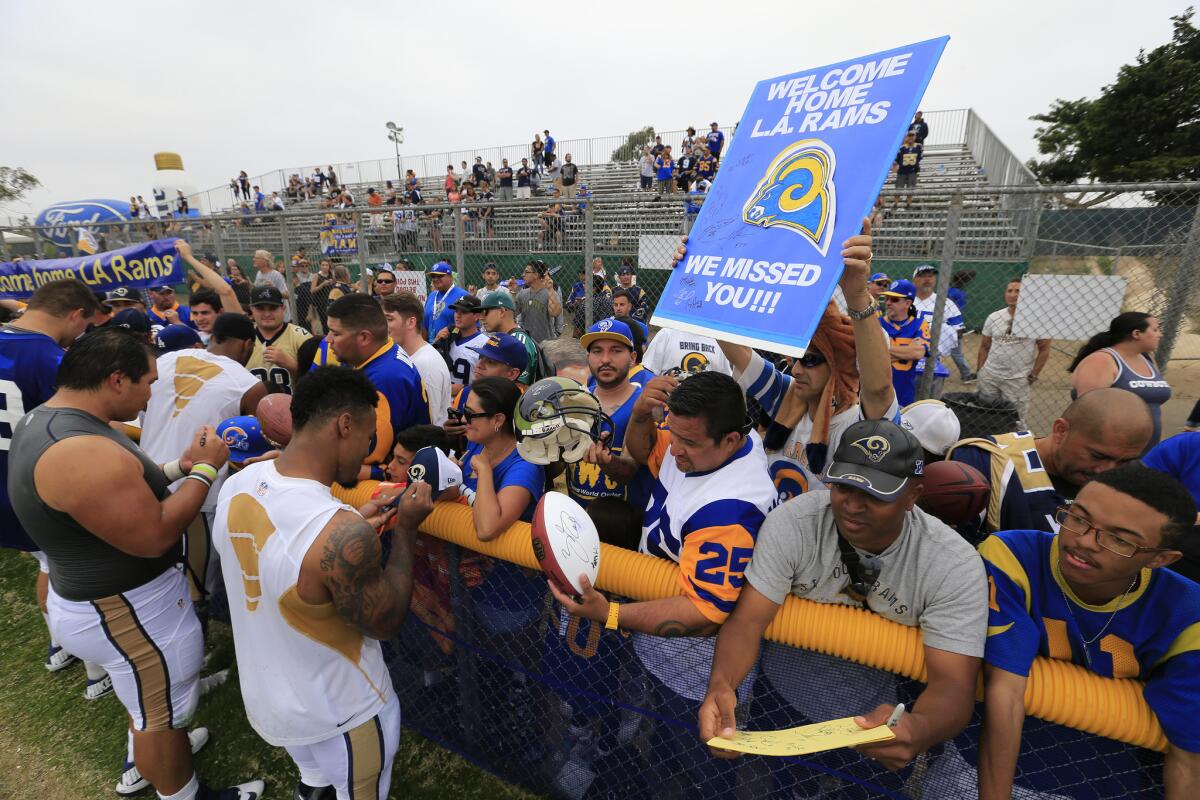 St. Louis Rams players sign autographs for fans following a Rams-Dallas Cowboys scrimmage in Oxnard on Aug. 17, 2015.
