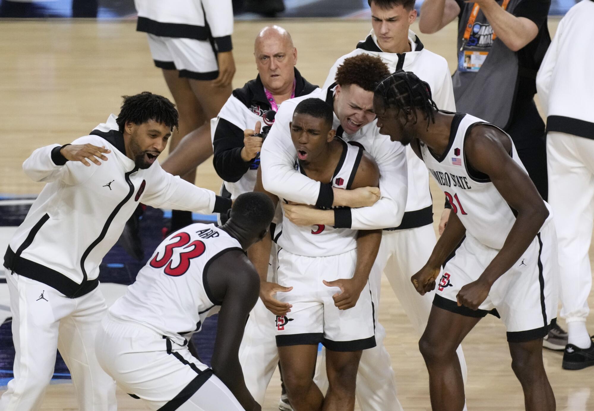 San Diego State guard Lamont Butler celebrates with teammates after he hit the winning basket 