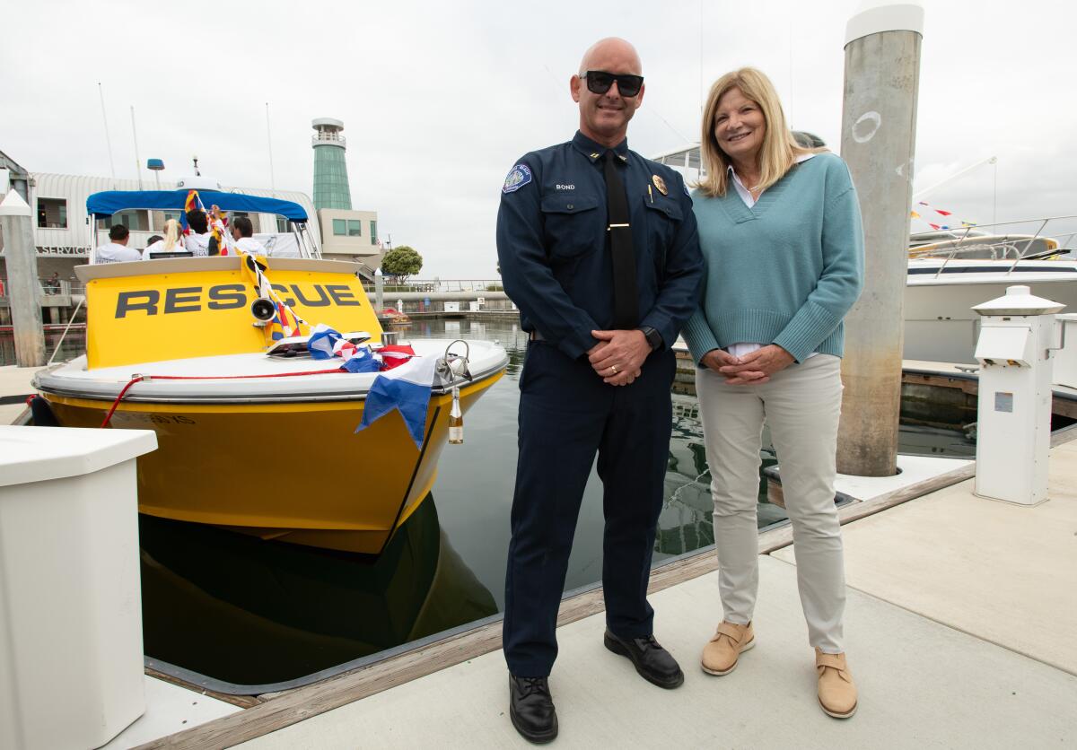 Laguna Beach Mayor Sue Kempf and Acting Marine Safety Chief Kai Bond pose for a photo next to the Wave Watch rescue vessel.